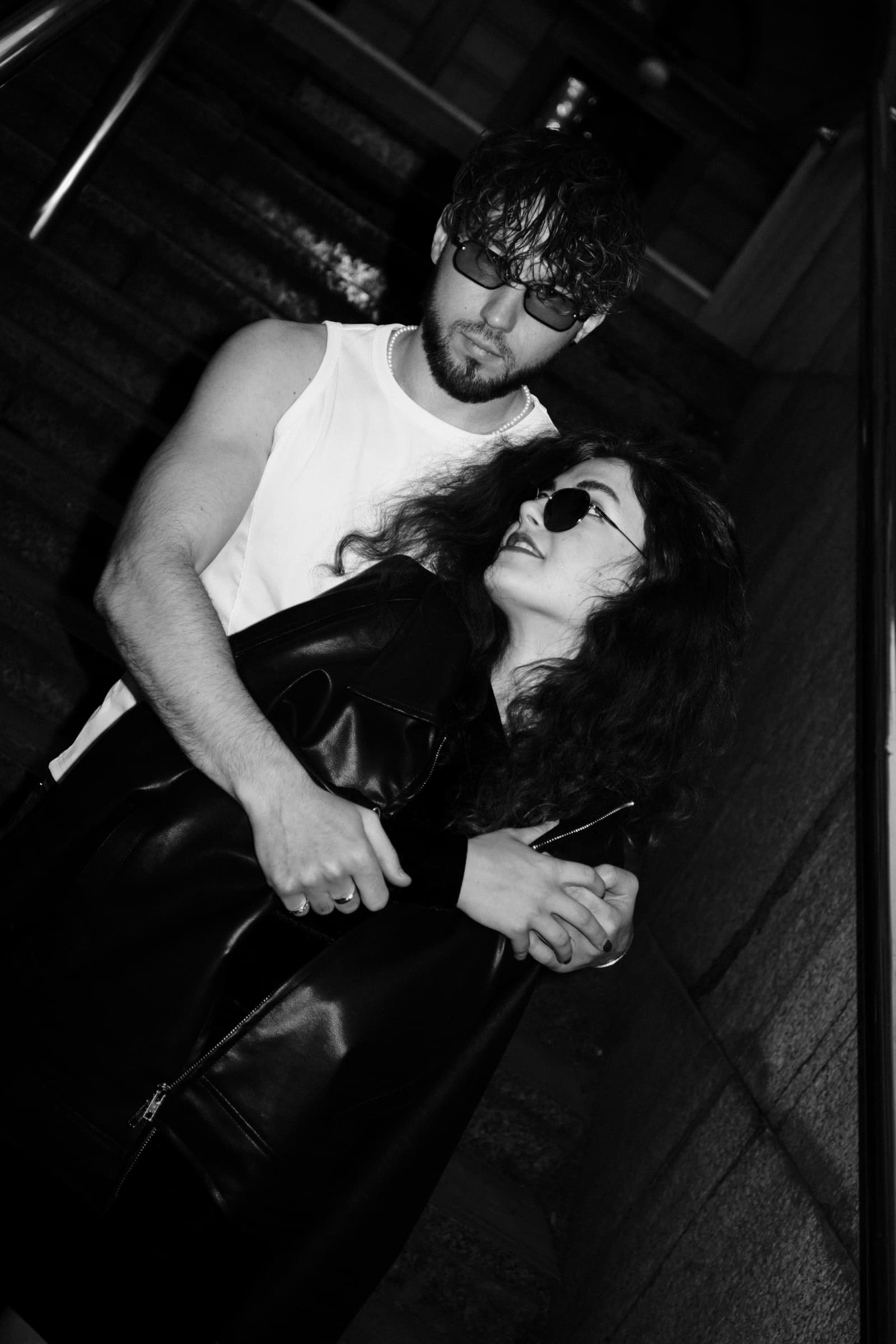 A couple in sunglasses embracing on a Prague staircase